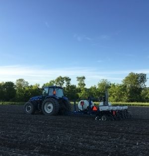 A blue tractor operating in a field.