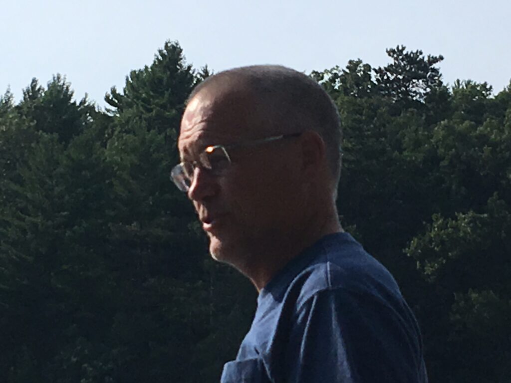 A photo of Lorenzo Whitcomb. He wears a blue shirt and glasses.